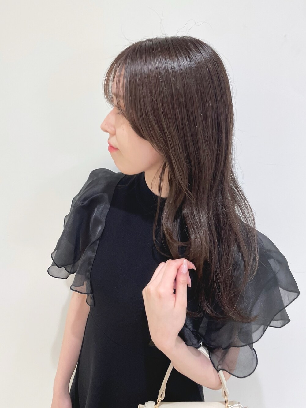 ブラック系のワンピース、ホワイト系のハンドバッグ、ホワイト系のブーツを着用したレディースの春コーディネートの8枚目の写真