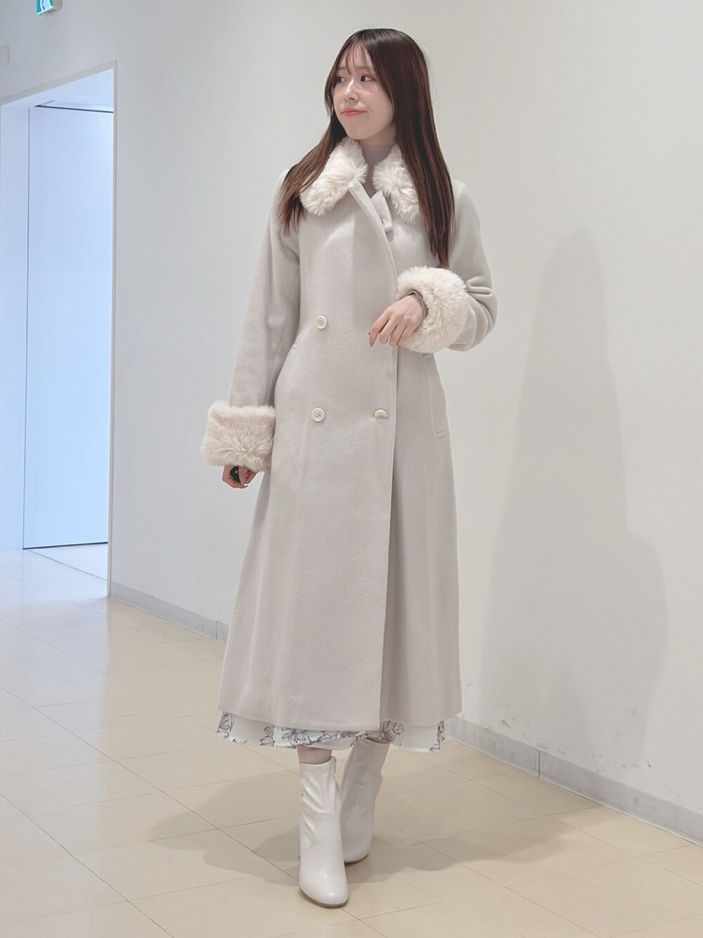 ホワイト系のその他アウター、ベージュ系のワンピース、ホワイト系のブーツを着用したレディースの冬コーディネートの3枚目の写真