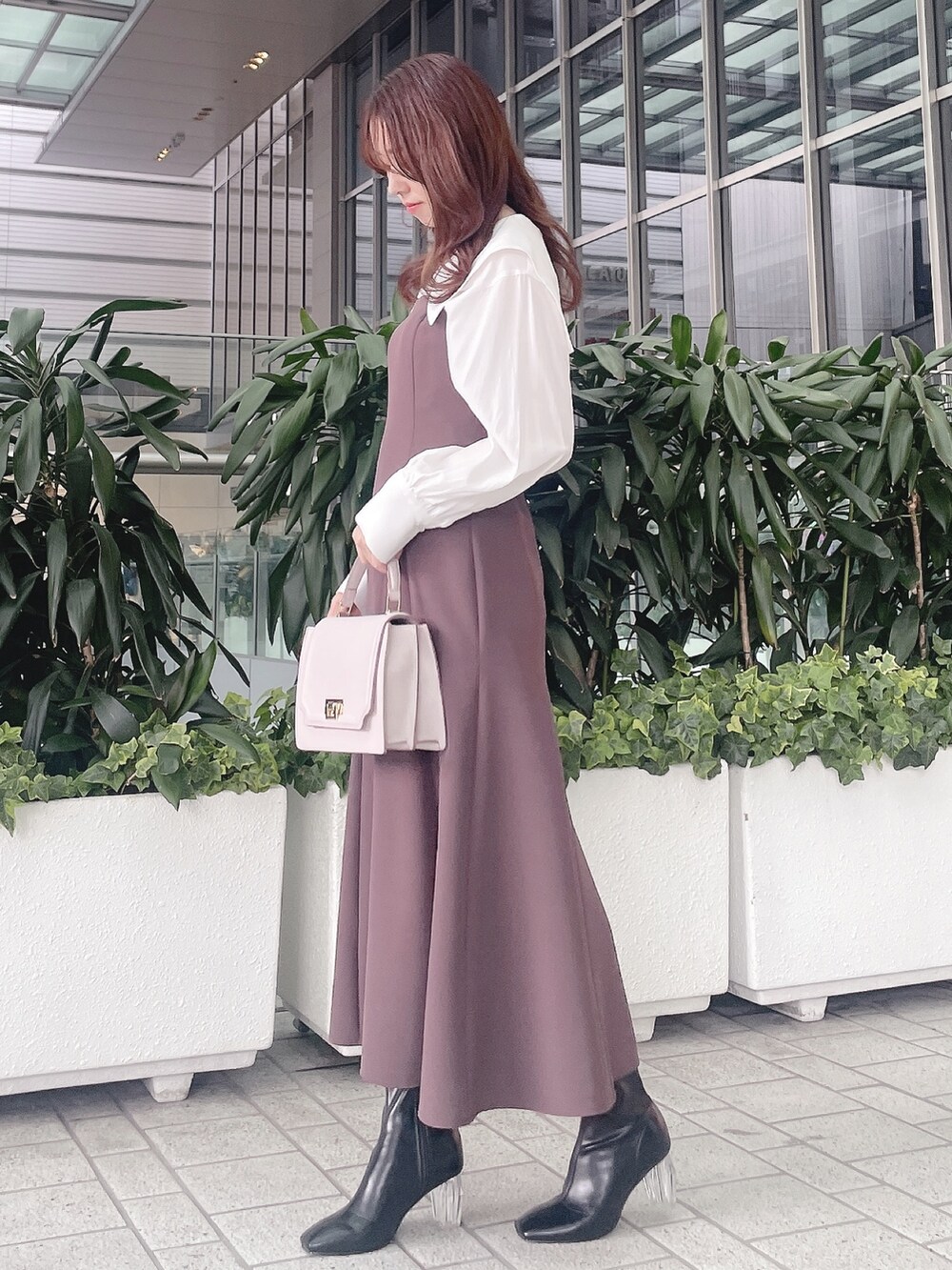 パープル系のワンピース、ブラック系のブーツを着用したレディースの冬コーディネートの3枚目の写真