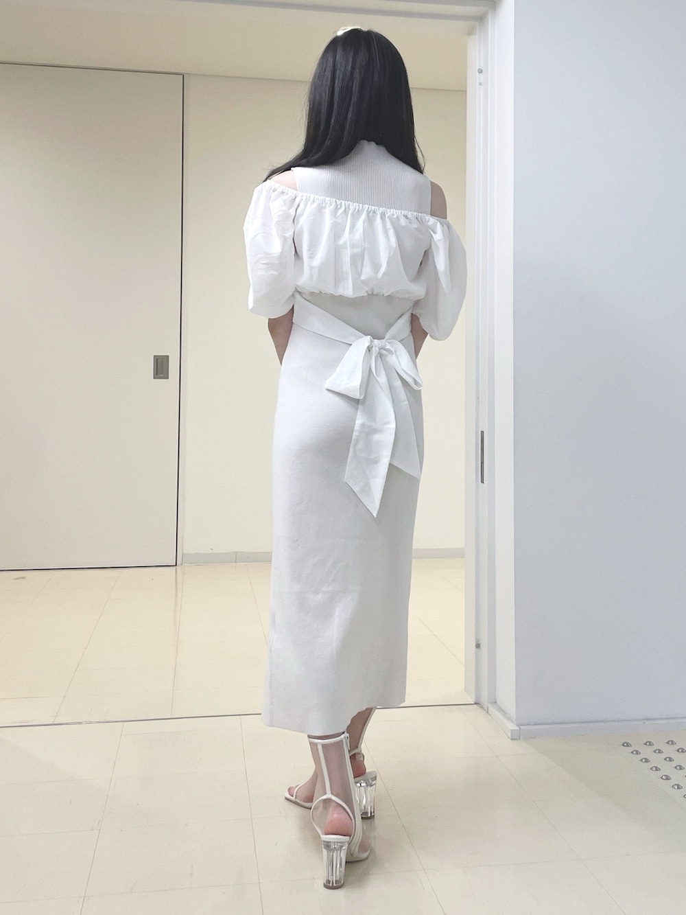 ホワイト系のワンピース、ブラック系のハンドバッグ、ホワイト系のブーツを着用したレディースの春コーディネートの6枚目の写真