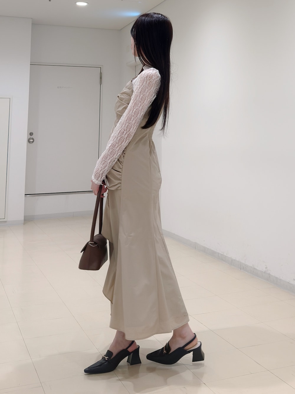 ベージュ系のワンピース、ブラウン系のハンドバッグ、ブラウン系のパンプスを着用したレディースの春コーディネートの4枚目の写真