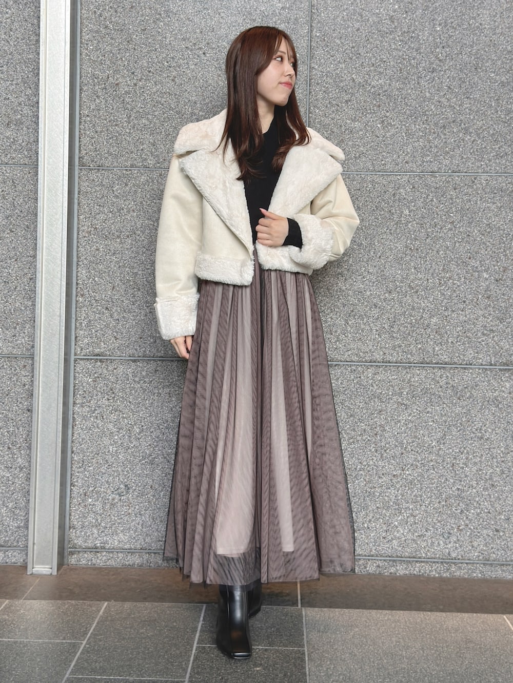 ホワイト系のムートンコート、ブラック系のワンピース、ブラック系のブーツを着用したレディースの秋コーディネートの3枚目の写真