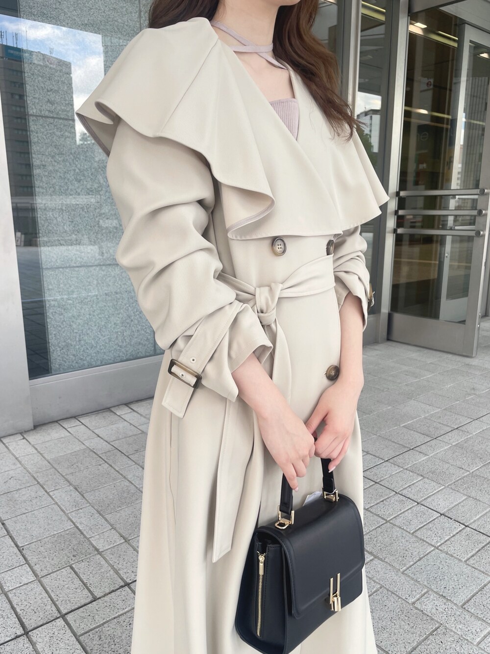 ピンク系のワンピース、ベージュ系のトレンチコート、ブラック系のショルダーバッグを着用したレディースの秋コーディネートの6枚目の写真