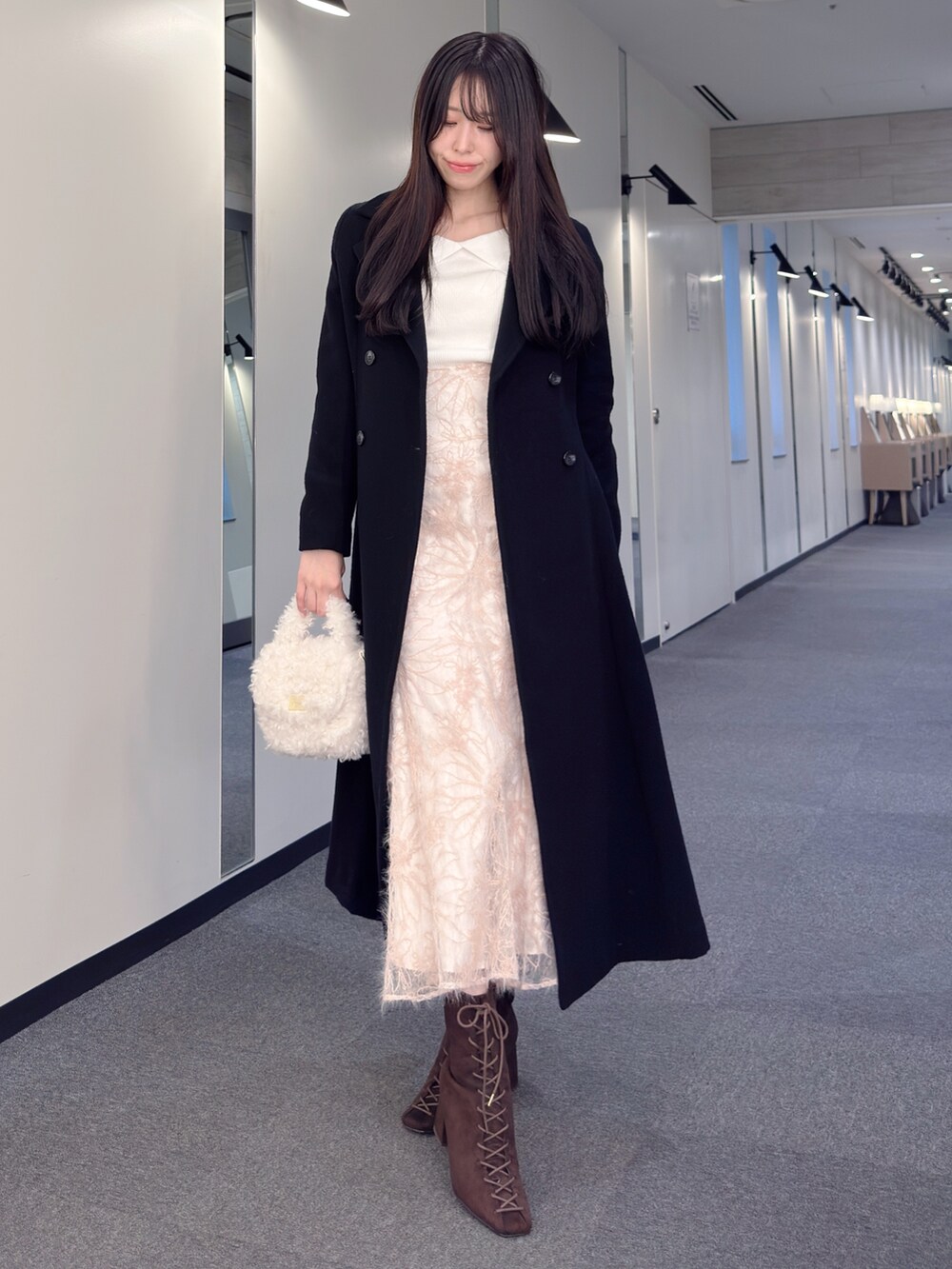 ブラック系のその他アウター、ホワイト系のニット/セーター、ピンク系のスカートを着用したレディースの秋コーディネートの2枚目の写真