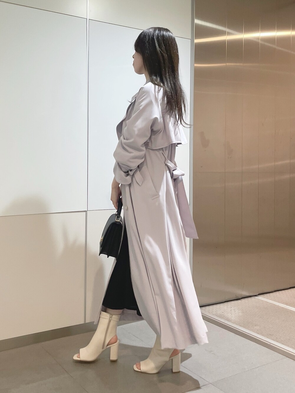 ブラック系のハンドバッグ、パープル系のトレンチコート、ホワイト系のニット/セーターを着用したレディースの冬コーディネートの4枚目の写真