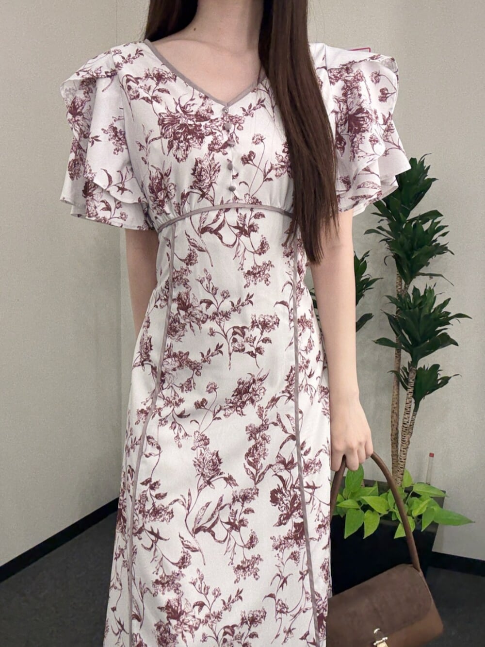 ブラウン系のハンドバッグ、ブラウン系のパンプス、レッド系のワンピースを着用したレディースの夏コーディネートの5枚目の写真