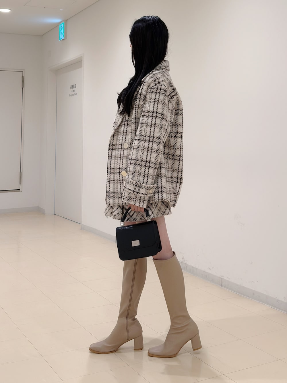 ブラック系のニット/セーター、ホワイト系のその他アウター、ホワイト系のその他パンツを着用したレディースの秋コーディネートの4枚目の写真