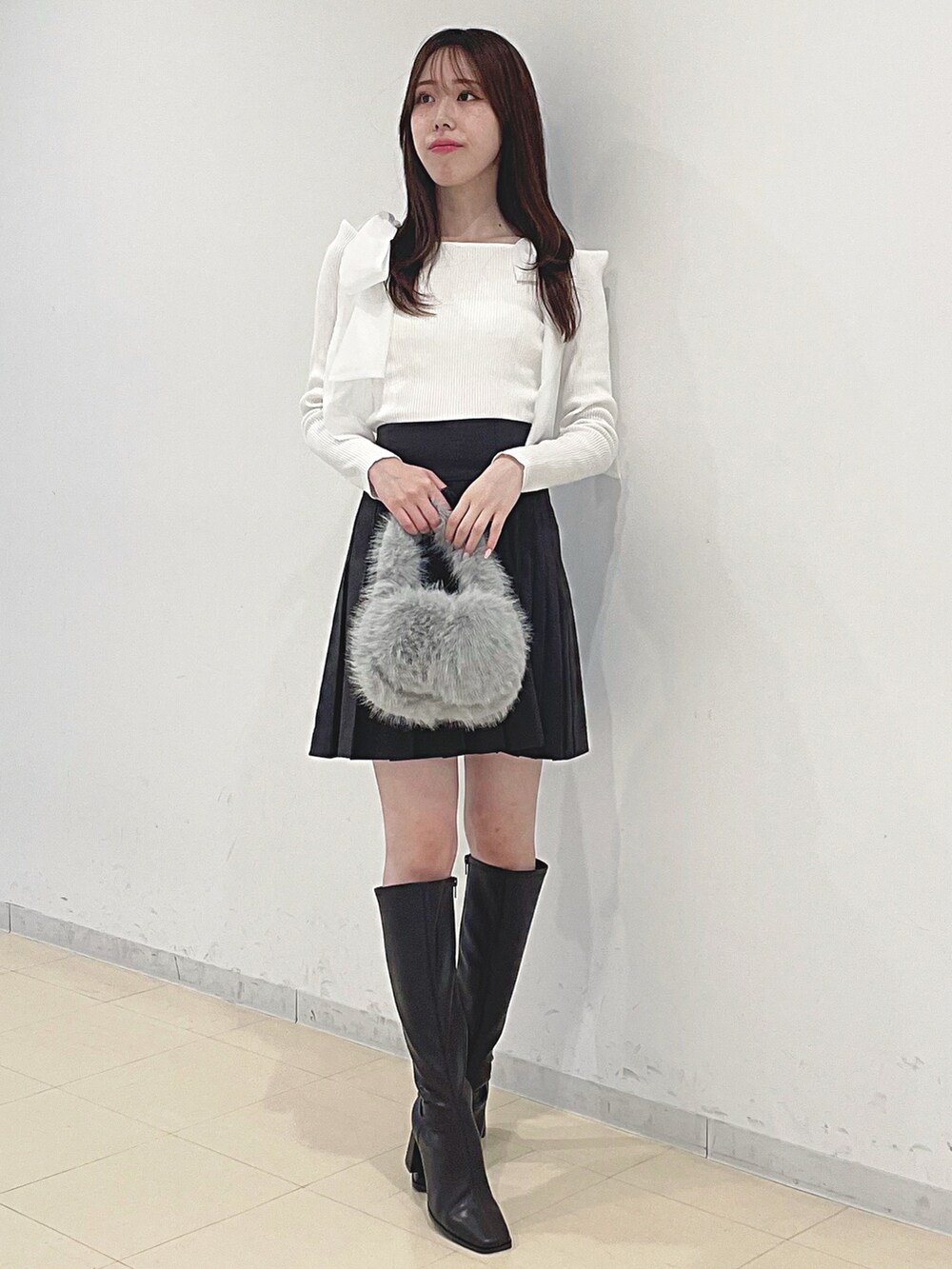 ホワイト系のニット/セーター、ブラウン系のその他パンツ、グレー系のハンドバッグを着用したレディースの秋コーディネートの2枚目の写真