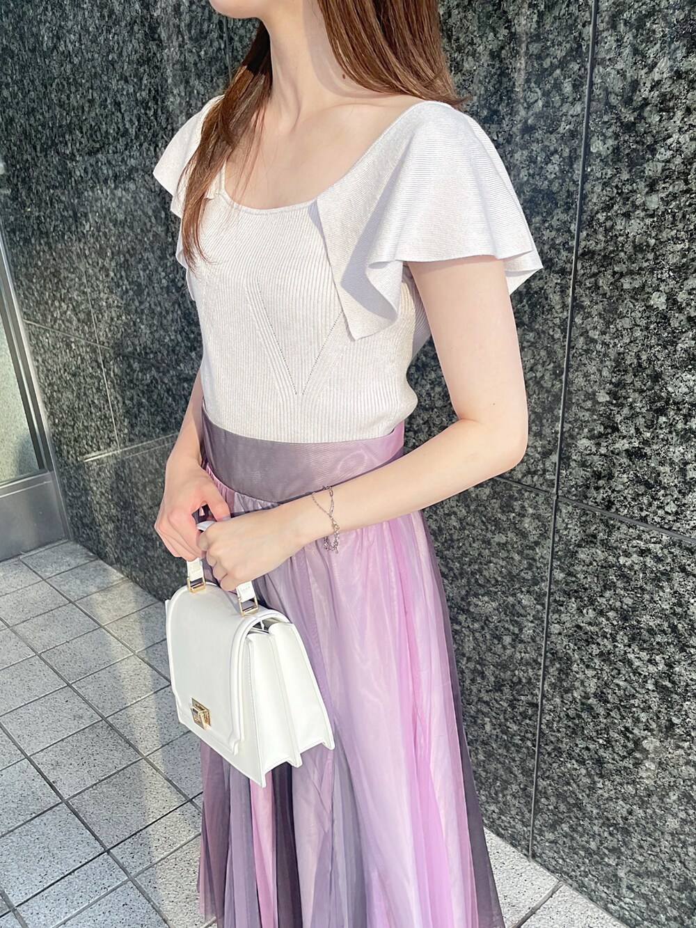 ピンク系のニット/セーター、ホワイト系のハンドバッグ、ホワイト系のブーツを着用したレディースの夏コーディネートの6枚目の写真