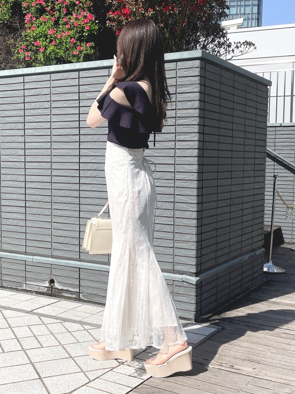 ブルー系のニット/セーター、ホワイト系のスカート、ホワイト系のハンドバッグを着用したレディースの春コーディネートの4枚目の写真