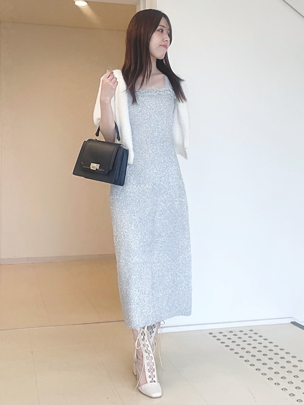 ホワイト系のカーディガン/ボレロ、シルバー系のワンピース、ブラック系のハンドバッグを着用したレディースの秋コーディネートの2枚目の写真