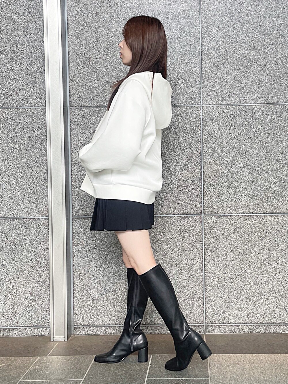 ホワイト系のパーカー、ブラック系のその他パンツ、ブラック系のブーツを着用したレディースの秋コーディネートの5枚目の写真