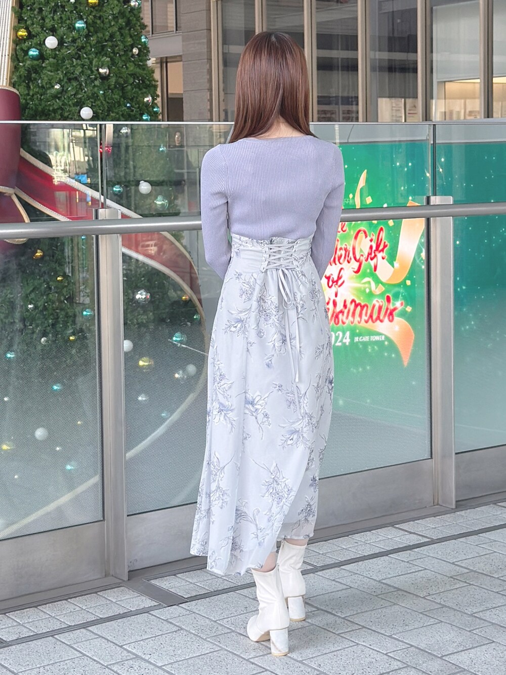 パープル系のワンピース、ホワイト系のブーツ、ブラウン系のハンドバッグを着用したレディースの秋コーディネートの5枚目の写真