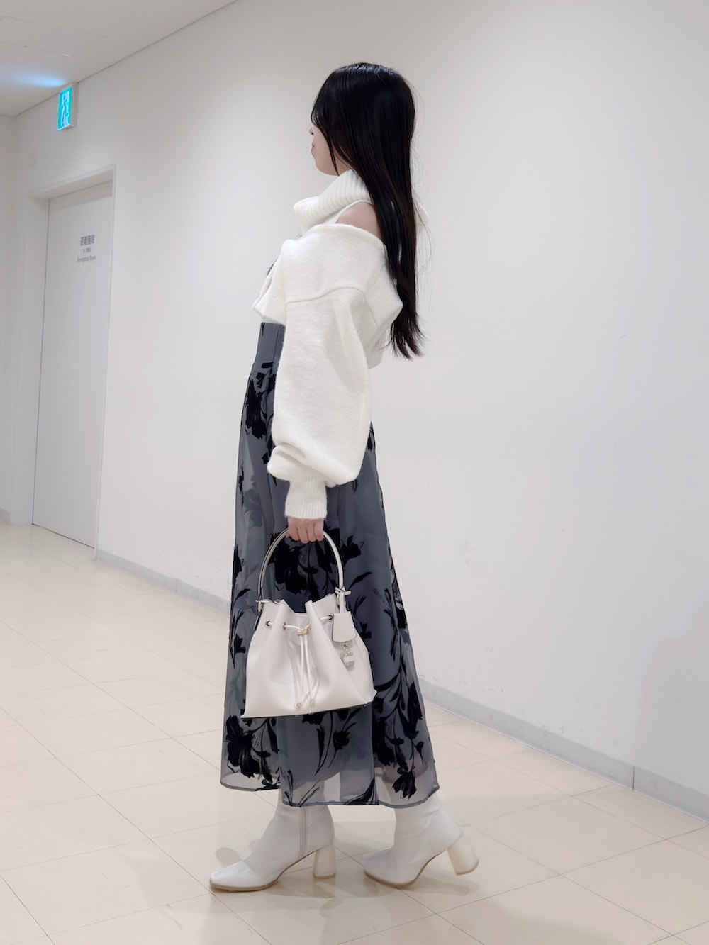 ホワイト系のニット/セーター、ブラック系のスカート、ホワイト系のショルダーバッグを着用したレディースの冬コーディネートの3枚目の写真