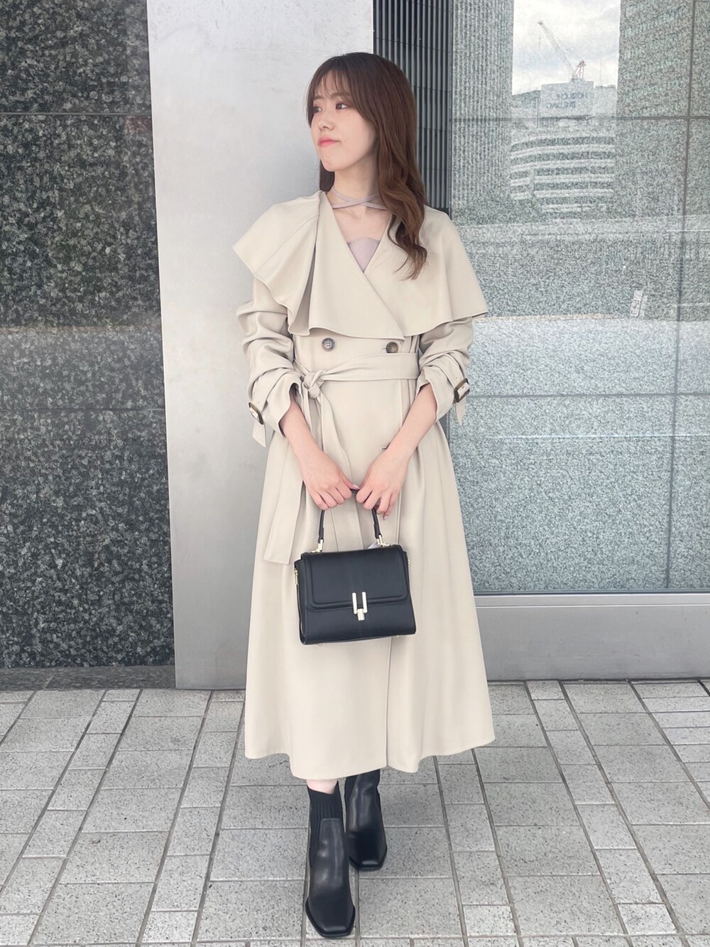 ピンク系のワンピース、ベージュ系のトレンチコート、ブラック系のショルダーバッグを着用したレディースの秋コーディネートの2枚目の写真