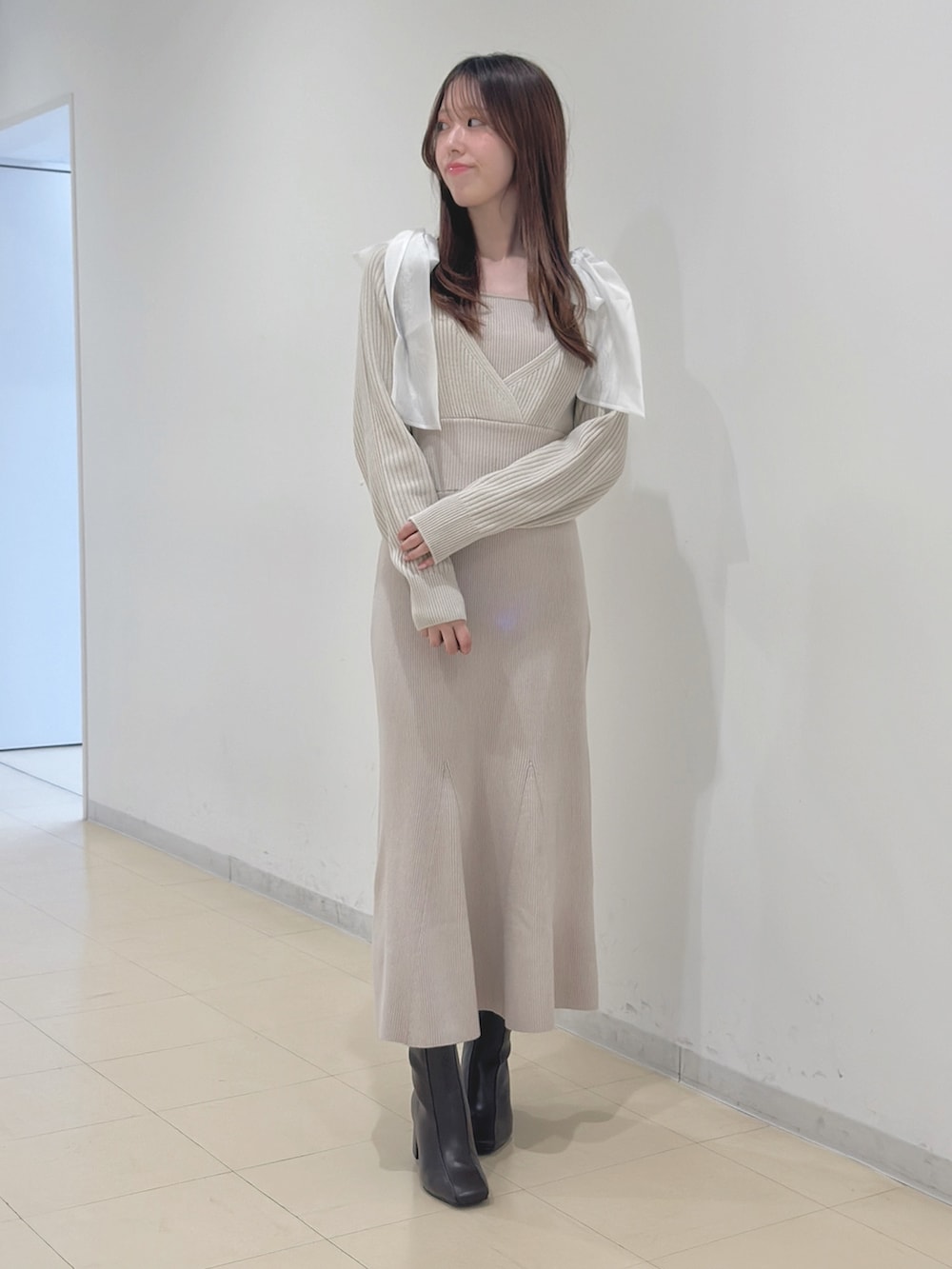 ホワイト系のワンピース、ブラウン系のブーツを着用したレディースの冬コーディネートの2枚目の写真