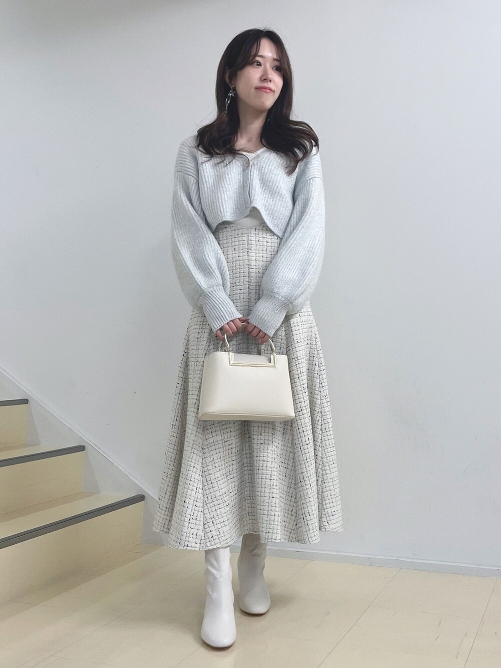 ホワイト系のニット/セーター、ホワイト系のスカート、ホワイト系のハンドバッグを着用したレディースの秋コーディネートの3枚目の写真