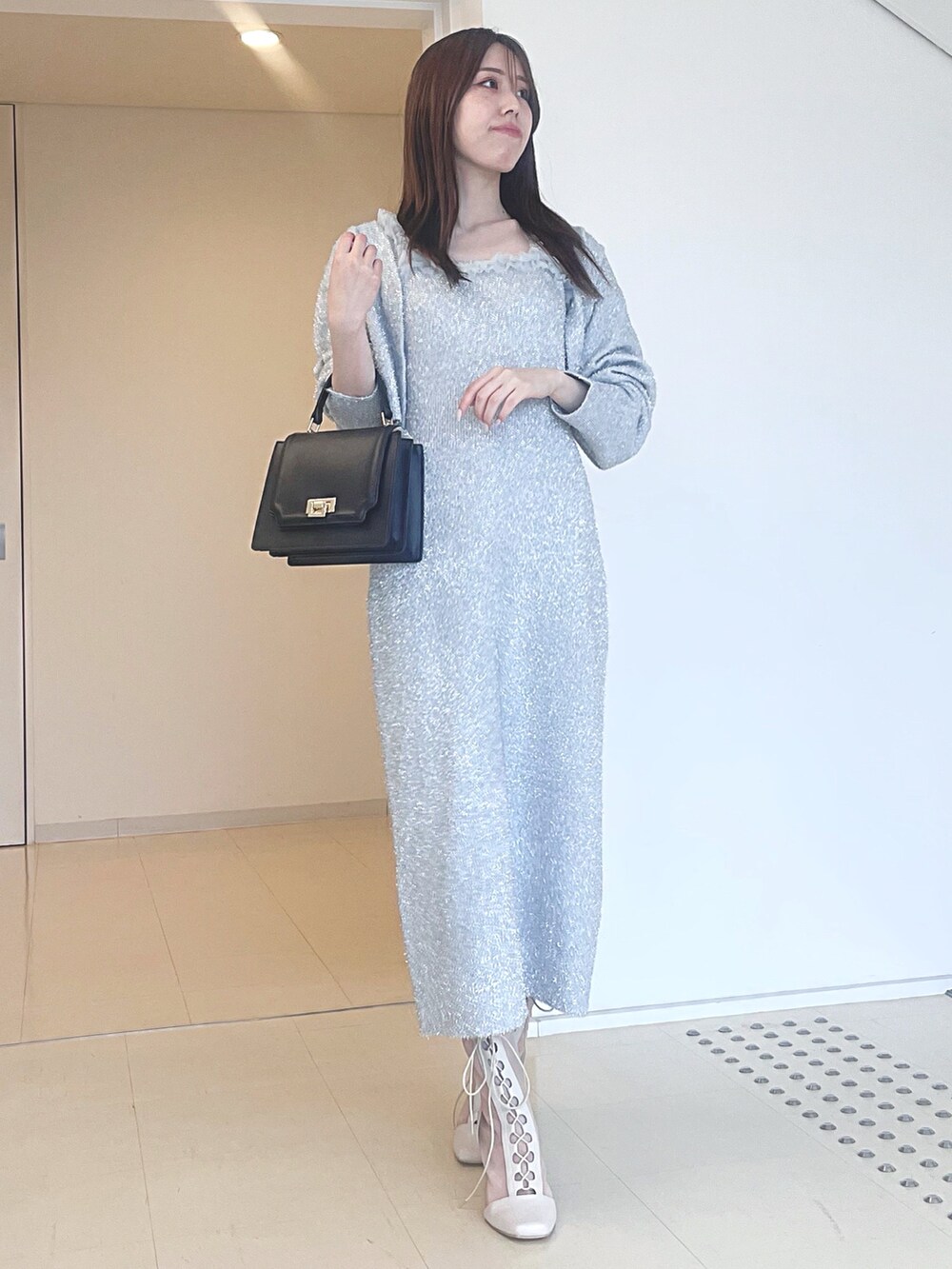 ホワイト系のブーツ、ブラック系のハンドバッグ、シルバー系のワンピースを着用したレディースの秋コーディネートの3枚目の写真