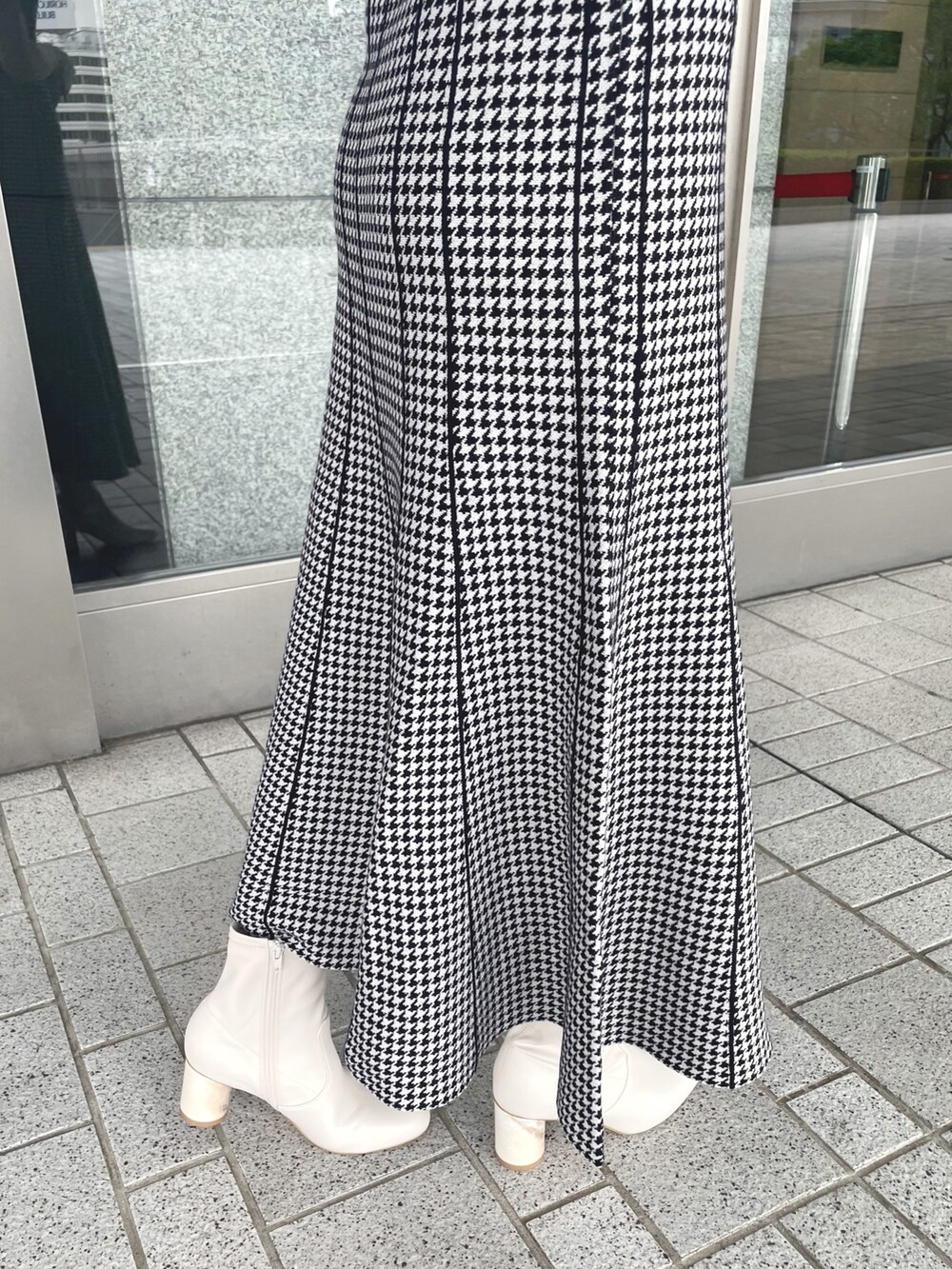 ブラック系のワンピース、ホワイト系のショルダーバッグ、ホワイト系のブーツを着用したレディースの夏コーディネートの6枚目の写真