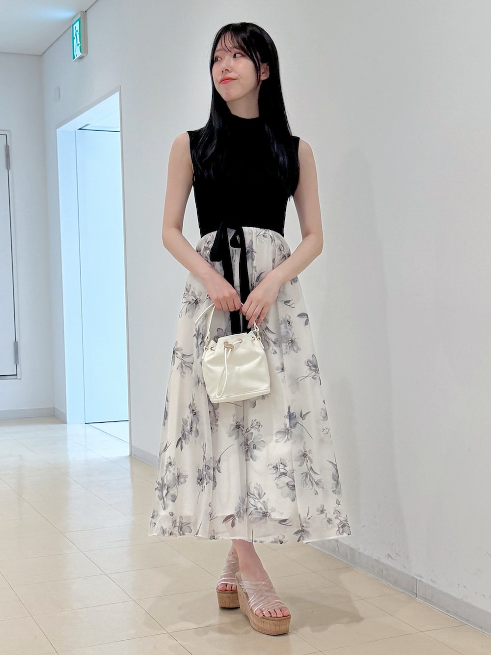 ホワイト系のワンピース、ホワイト系のハンドバッグ、その他のサンダルを着用したレディースの春コーディネートの2枚目の写真