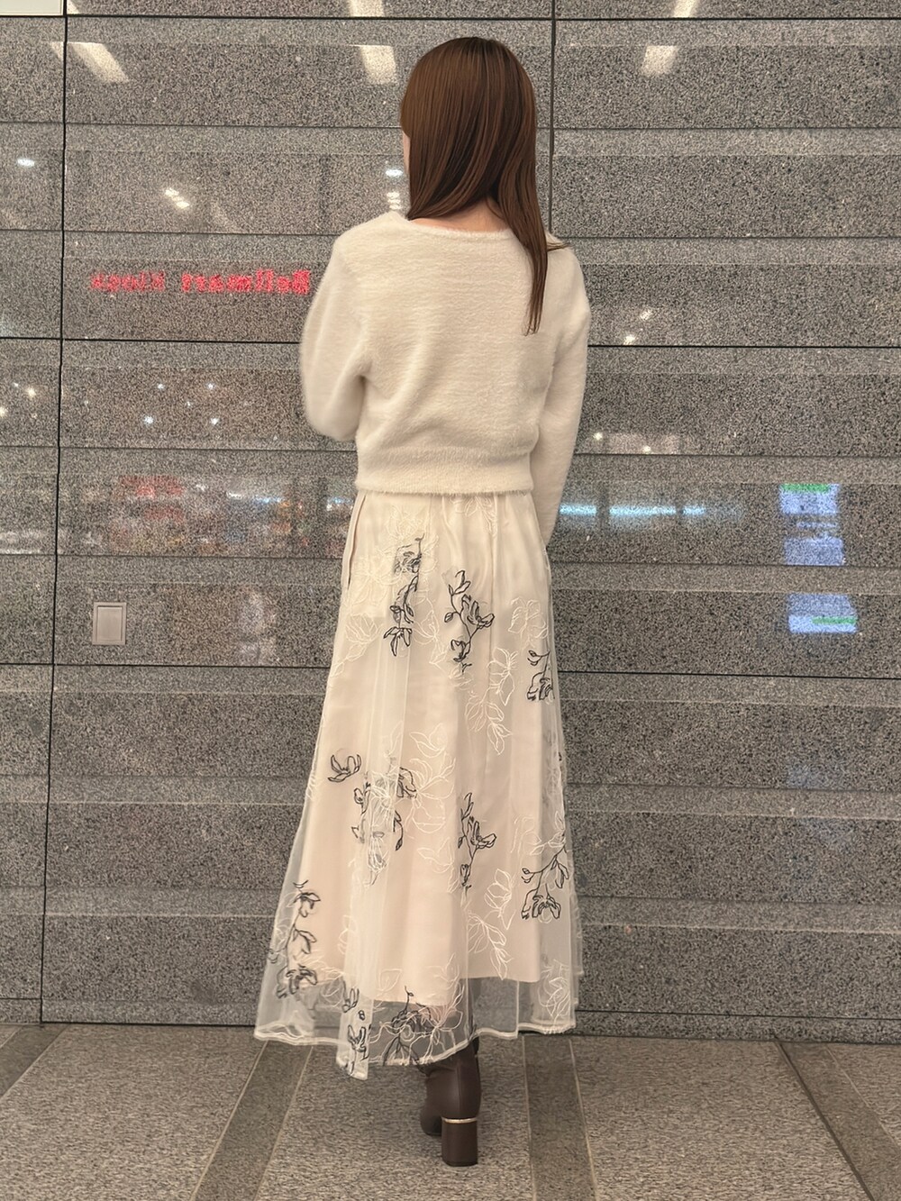 ホワイト系のカーディガン/ボレロ、ホワイト系のスカート、ブラック系のハンドバッグを着用したレディースの秋コーディネートの5枚目の写真