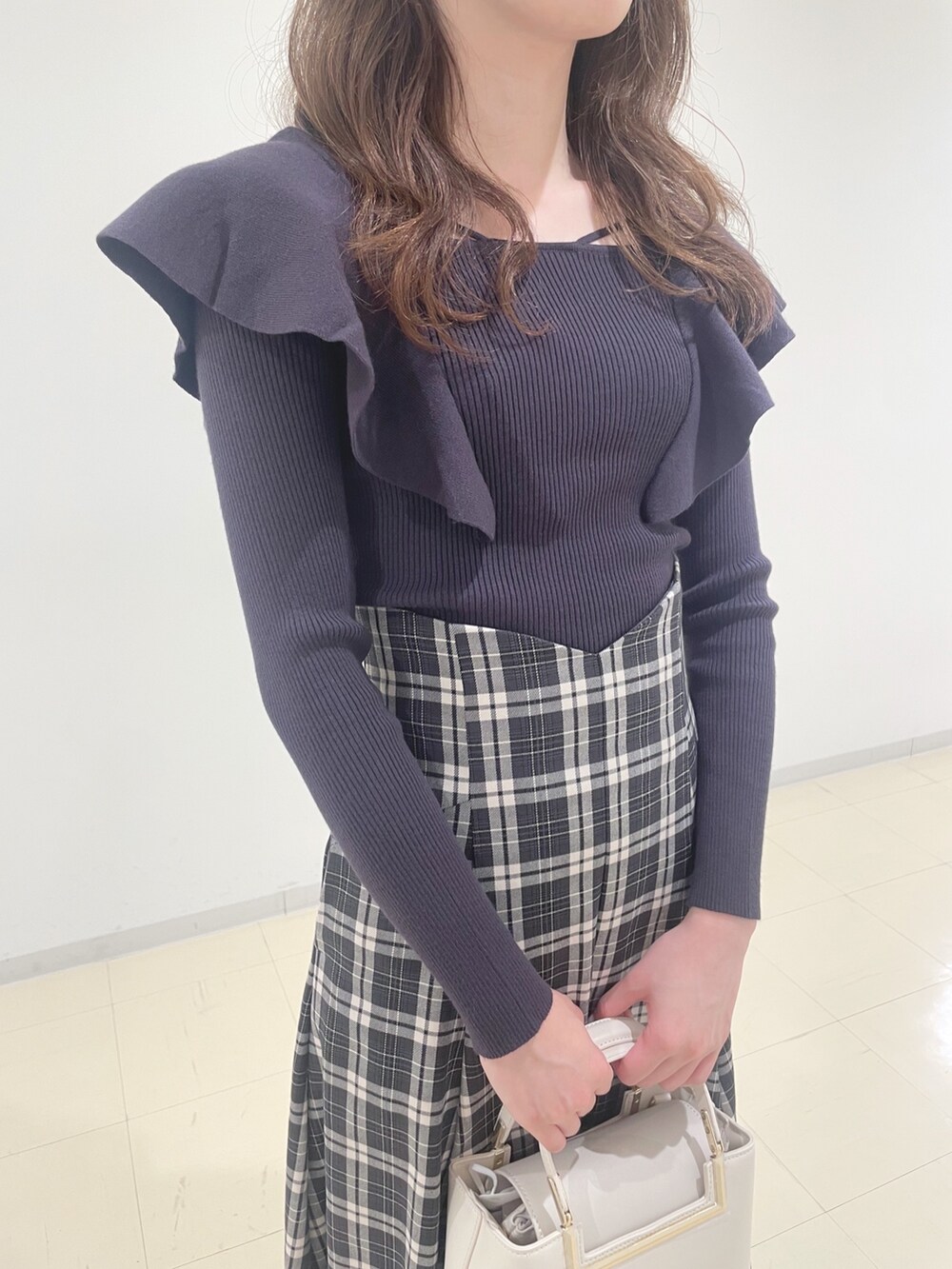 ベージュ系のブーツ、ブラック系のスカート、グレー系のニット/セーターを着用したレディースの秋コーディネートの5枚目の写真