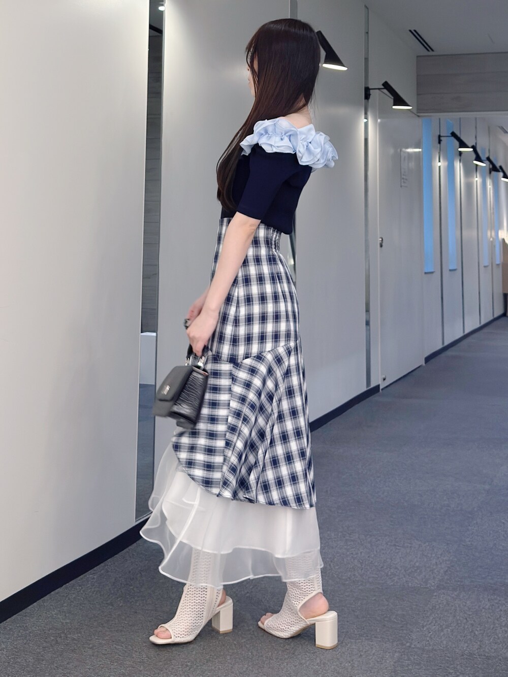 ブルー系のニット/セーター、その他のスカート、ブラック系のハンドバッグを着用したレディースの春コーディネートの3枚目の写真