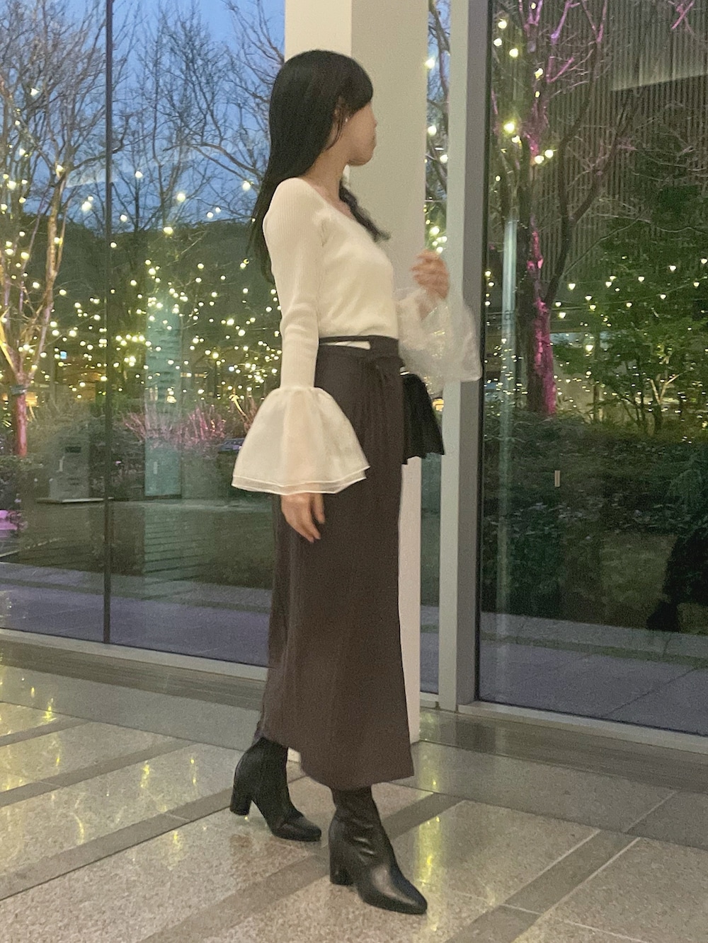 ホワイト系のテーラードジャケット、ホワイト系のニット/セーター、グレー系のスカートを着用したレディースの冬コーディネートの7枚目の写真