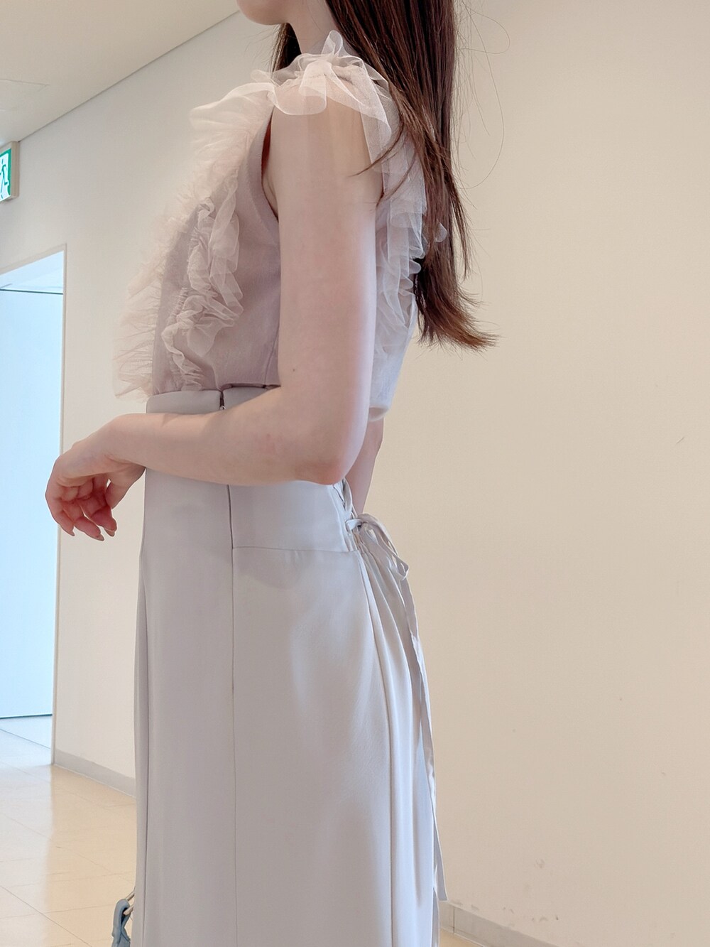 ピンク系のニット/セーター、ホワイト系のスカート、ブルー系のショルダーバッグを着用したレディースの春コーディネートの8枚目の写真