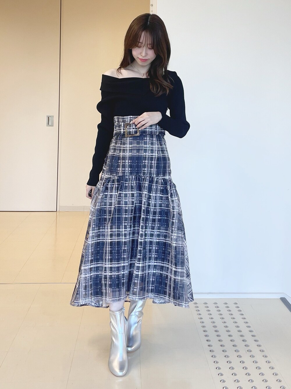 ブルー系のワンピース、シルバー系のブーツ、ブラック系のライダースジャケットを着用したレディースの冬コーディネートの5枚目の写真