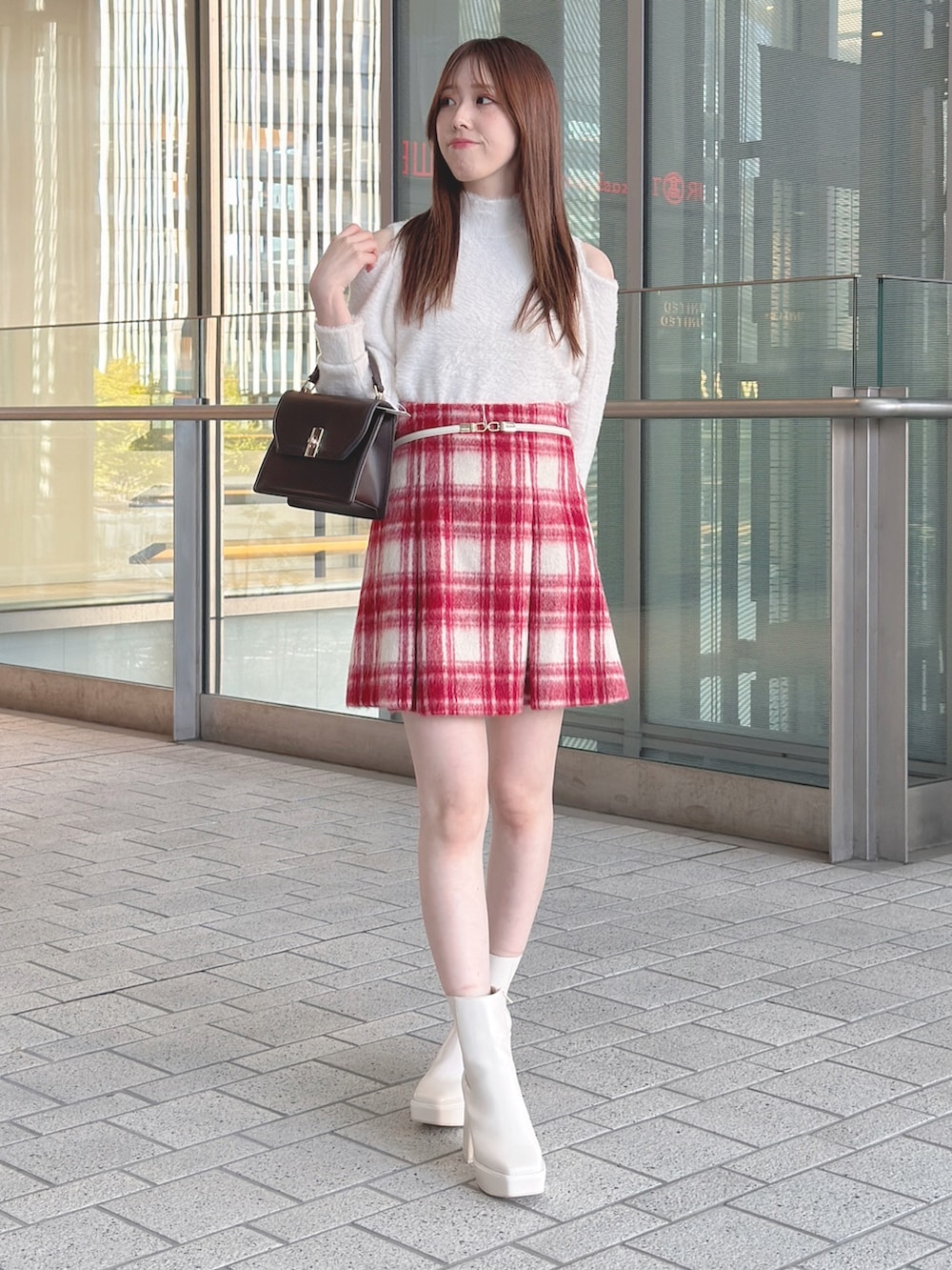 ブラウン系のチェスターコート、ホワイト系のニット/セーター、レッド系のその他パンツを着用したレディースの冬コーディネートの3枚目の写真