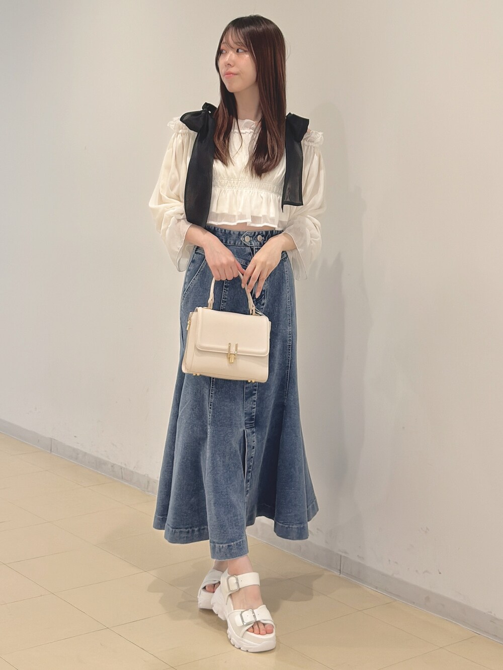 ホワイト系のシャツ/ブラウス、ブルー系のスカート、ホワイト系のハンドバッグを着用したレディースの春コーディネートの3枚目の写真