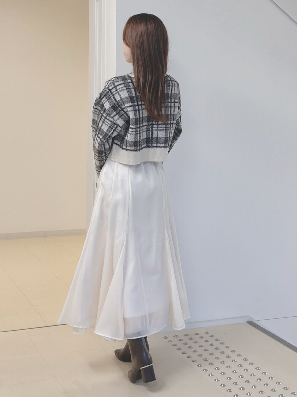 ホワイト系のカーディガン/ボレロ、ブラウン系のハンドバッグ、ホワイト系のスカートを着用したレディースの秋コーディネートの5枚目の写真
