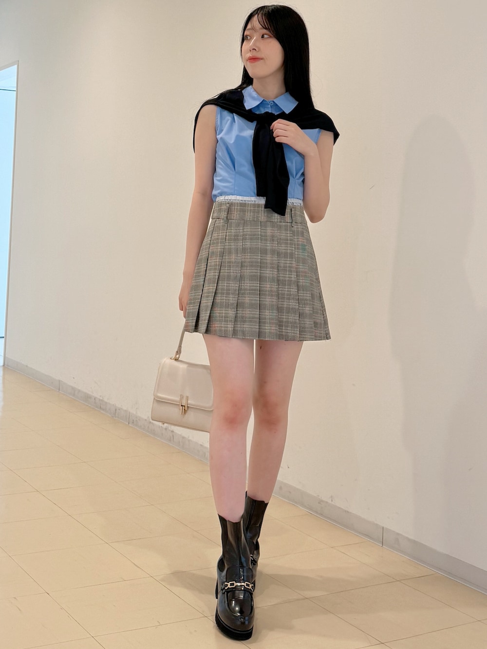 ブルー系のシャツ/ブラウス、グレー系のスカート、ホワイト系のハンドバッグを着用したレディースの夏コーディネートの3枚目の写真