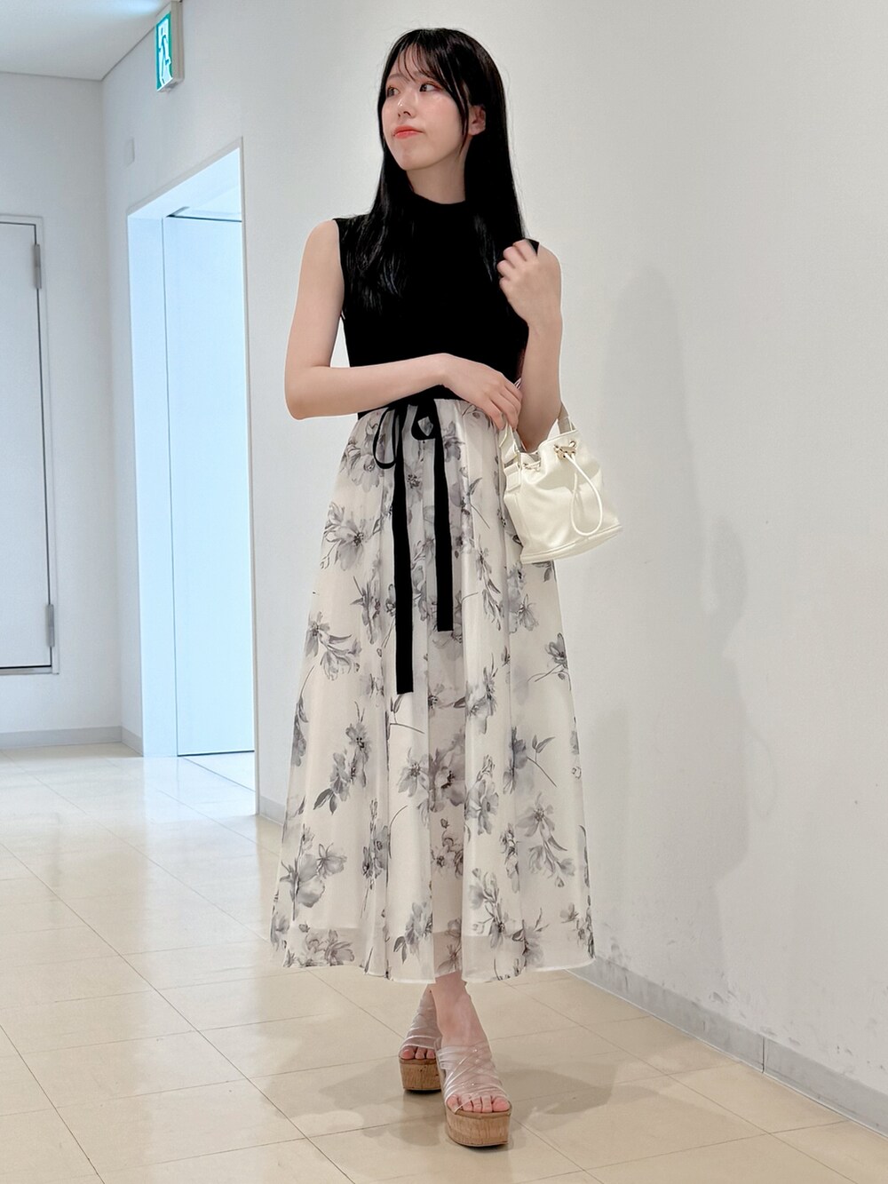 ホワイト系のワンピース、ホワイト系のハンドバッグ、その他のサンダルを着用したレディースの春コーディネートの3枚目の写真