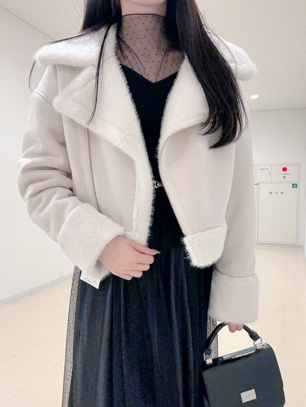 ブラウン系のブーツ、ブラック系のハンドバッグ、ブラック系のワンピースを着用したレディースの秋コーディネートの5枚目の写真