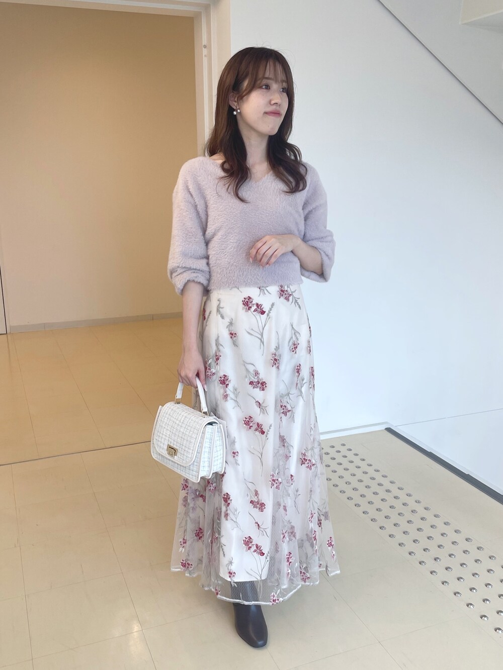 ピンク系のニット/セーター、ピンク系のスカート、ブラウン系のブーツを着用したレディースの秋コーディネートの2枚目の写真