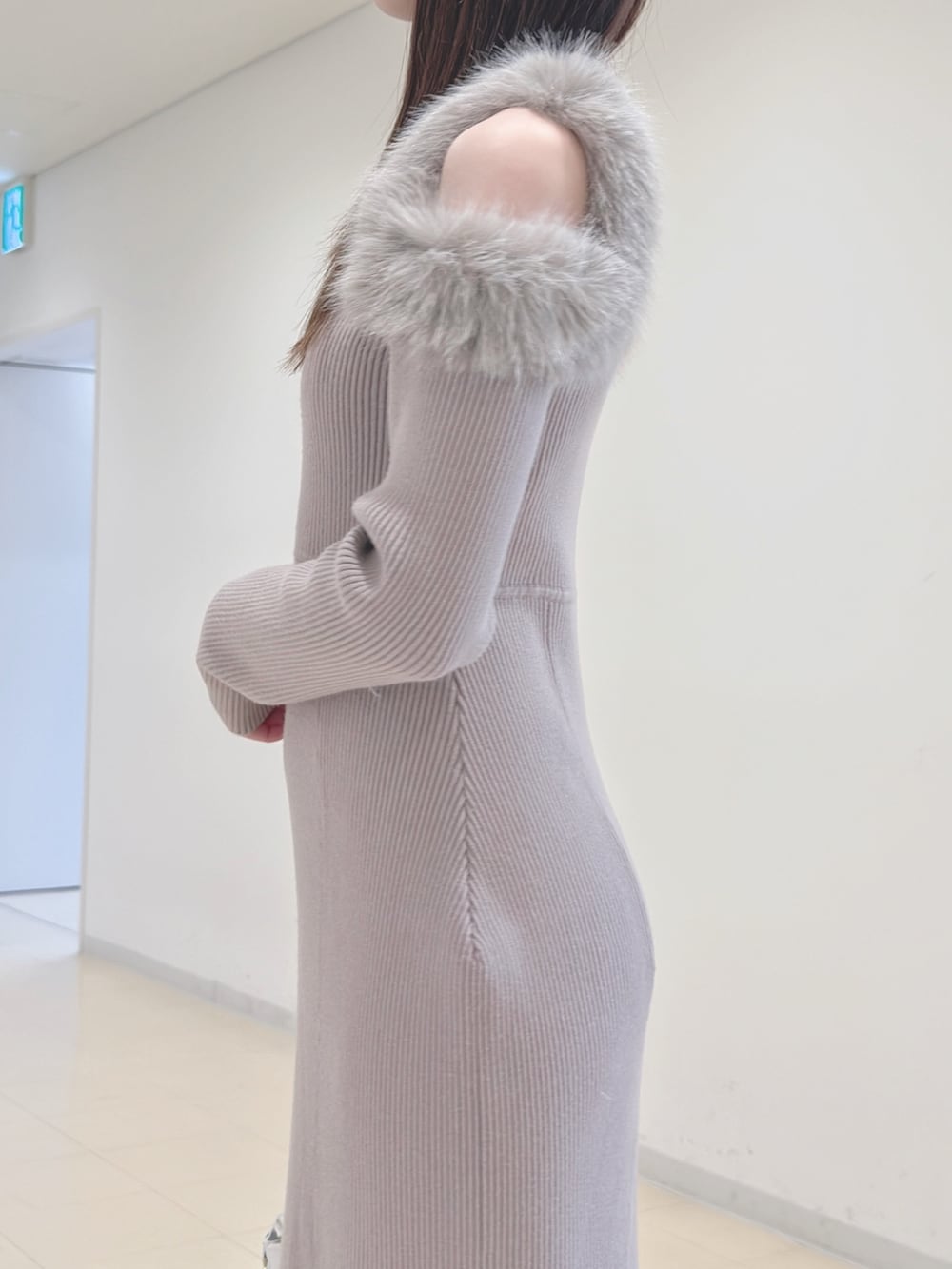 ベージュ系のワンピース、ホワイト系のハンドバッグ、ブラウン系のブーツを着用したレディースの冬コーディネートの8枚目の写真