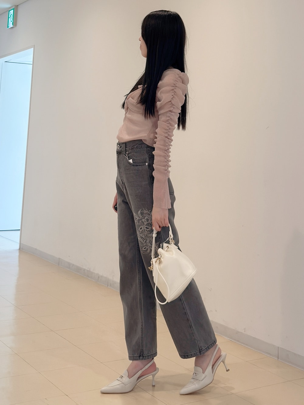 グレー系のデニムパンツ、ホワイト系のハンドバッグ、ピンク系のTシャツ/カットソーを着用したレディースの夏コーディネートの4枚目の写真