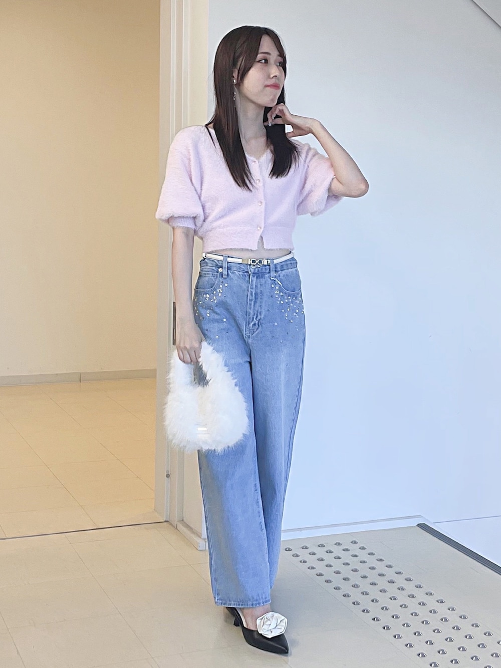 ピンク系のカーディガン/ボレロ、ブルー系のデニムパンツ、ホワイト系のハンドバッグを着用したレディースの夏コーディネートの2枚目の写真
