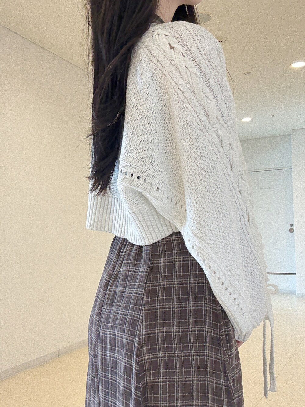 ホワイト系のカーディガン/ボレロ、ブラウン系のワンピース、ブラック系のブーツを着用したレディースの夏コーディネートの8枚目の写真