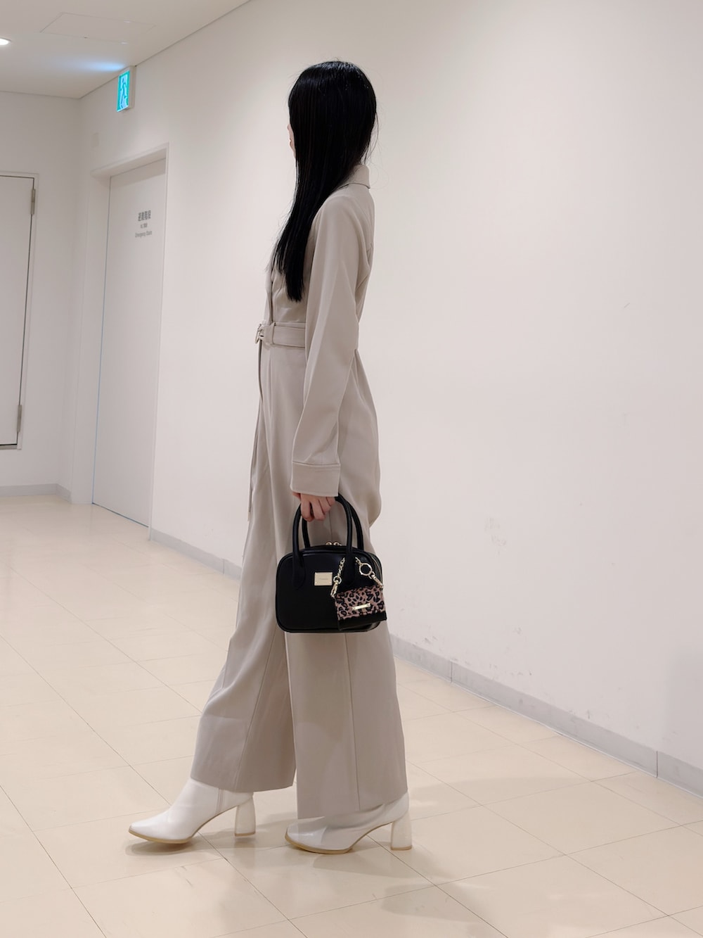 ベージュ系のつなぎ/オールインワン、ブラック系のハンドバッグ、ホワイト系のブーツを着用したレディースの秋コーディネートの3枚目の写真