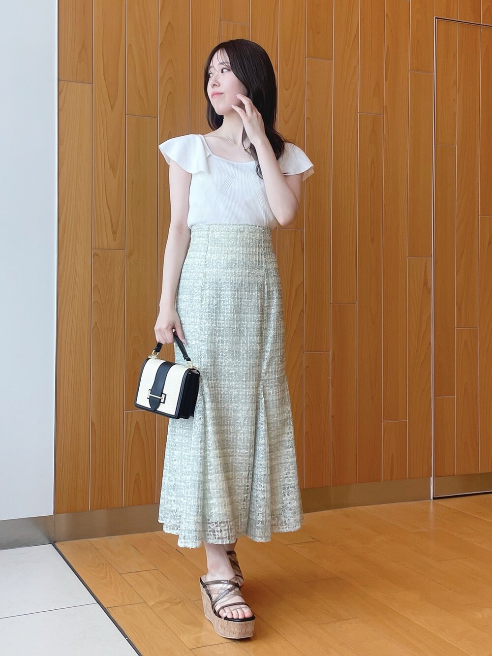 ベージュ系のシャツ/ブラウス、ホワイト系のニット/セーター、グリーン系のスカートを着用したレディースの春コーディネートの4枚目の写真