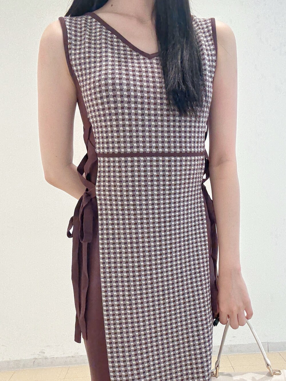 ブラウン系のワンピース、ホワイト系のハンドバッグ、グレー系のパンプスを着用したレディースの夏コーディネートの8枚目の写真