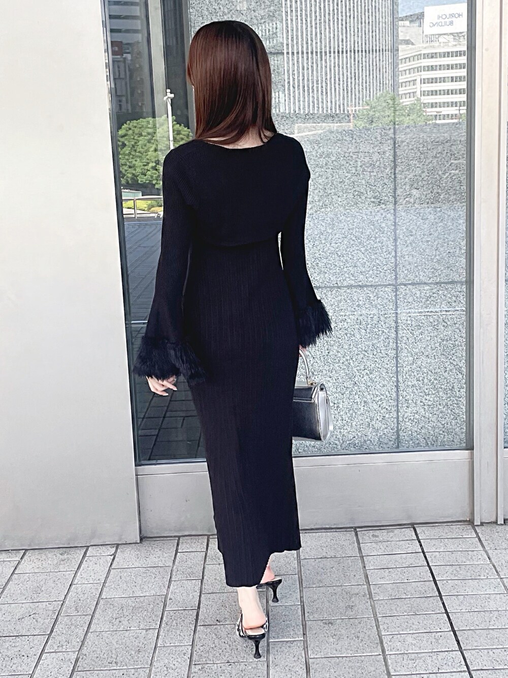 ブラック系のワンピース、シルバー系のハンドバッグ、その他のパンプスを着用したレディースの秋コーディネートの6枚目の写真