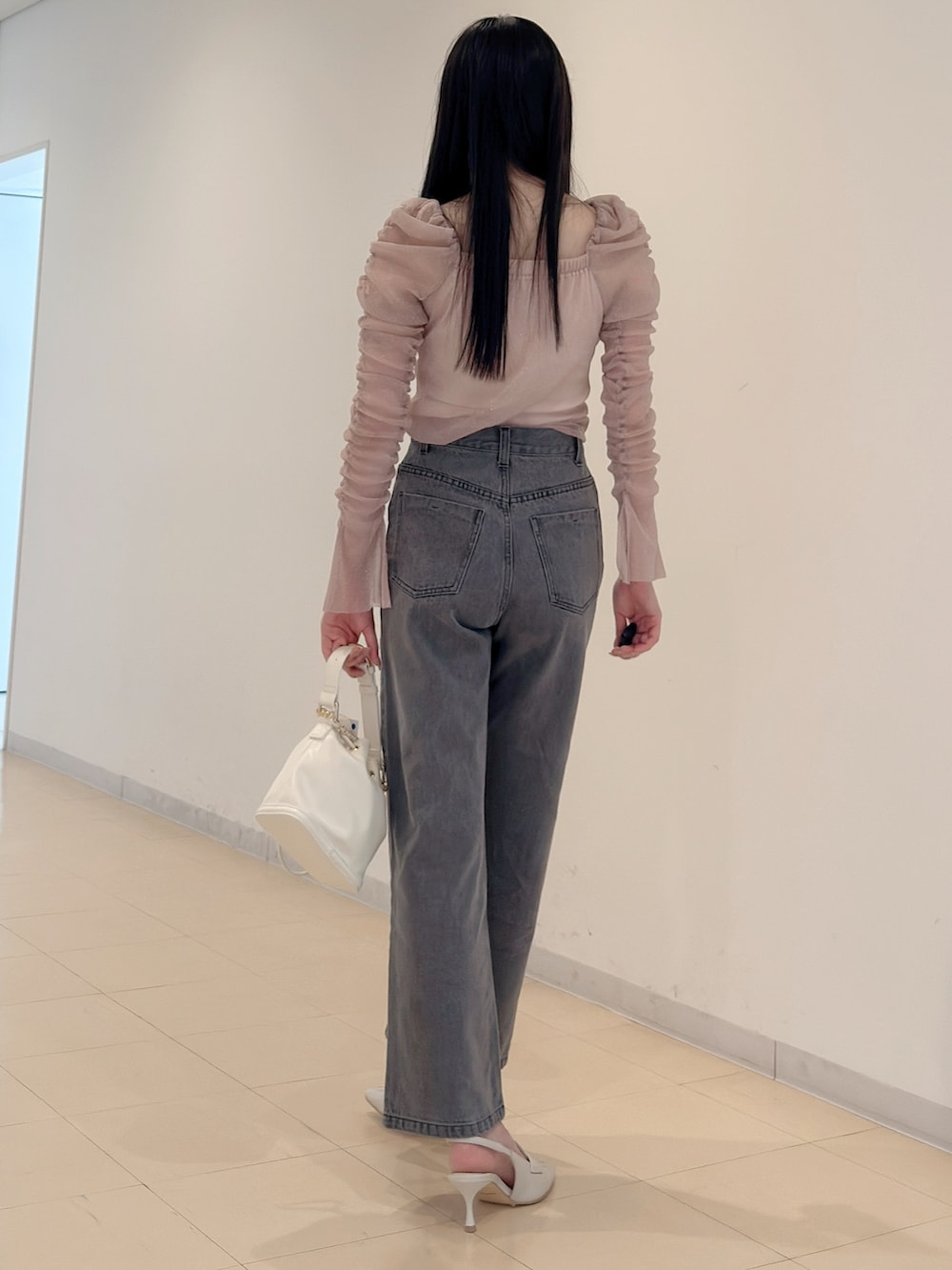 グレー系のデニムパンツ、ホワイト系のハンドバッグ、ピンク系のTシャツ/カットソーを着用したレディースの夏コーディネートの5枚目の写真