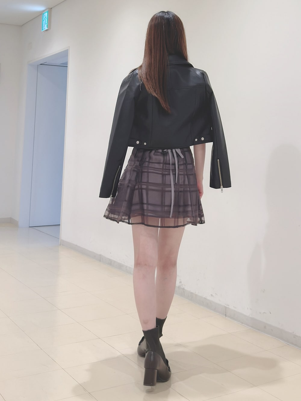 ブラック系のライダースジャケット、ベージュ系のニット/セーター、ブラウン系のその他パンツを着用したレディースの春コーディネートの5枚目の写真