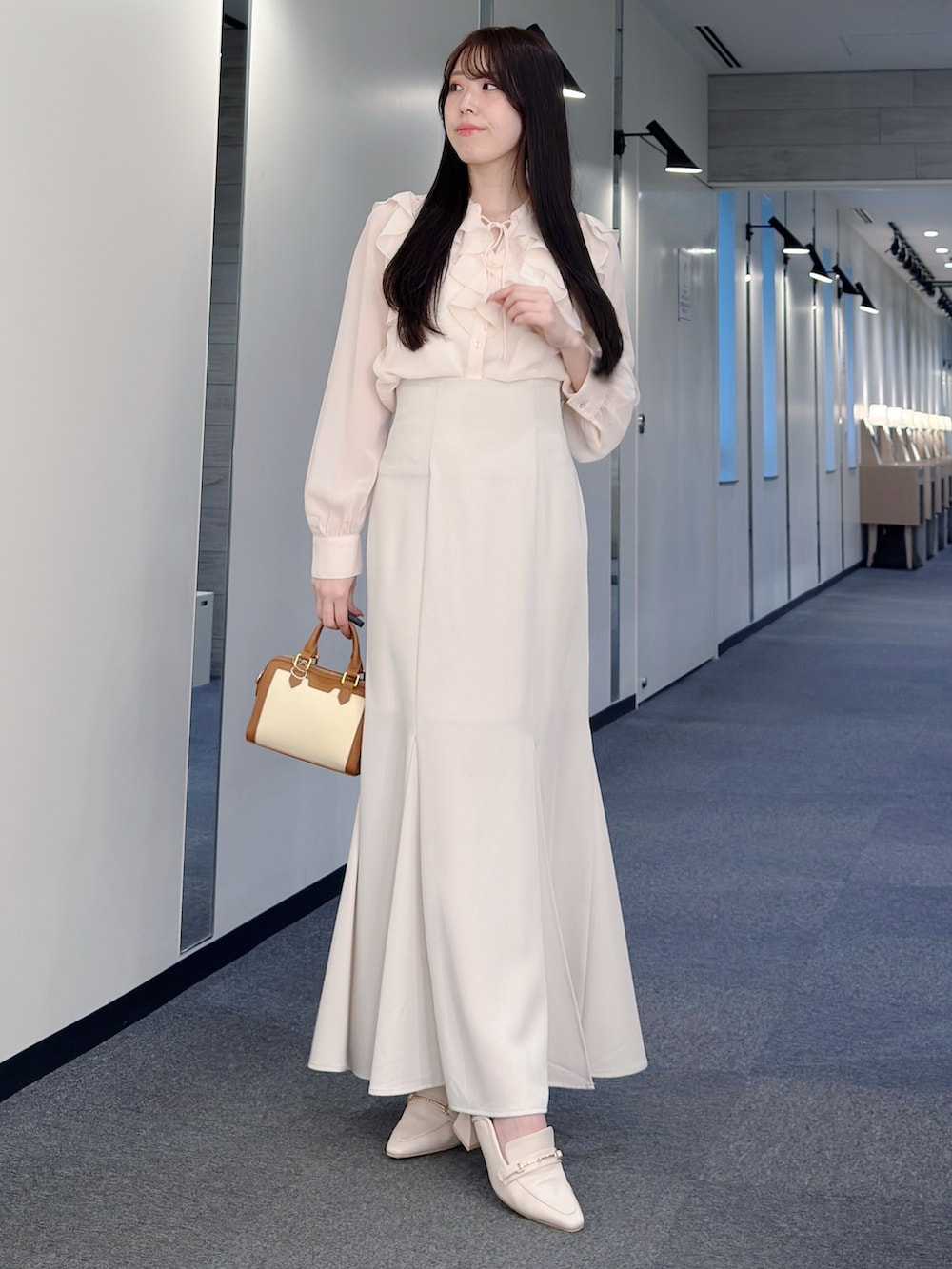ピンク系のシャツ/ブラウス、ホワイト系のスカート、ブラウン系のハンドバッグを着用したレディースの春コーディネートの3枚目の写真