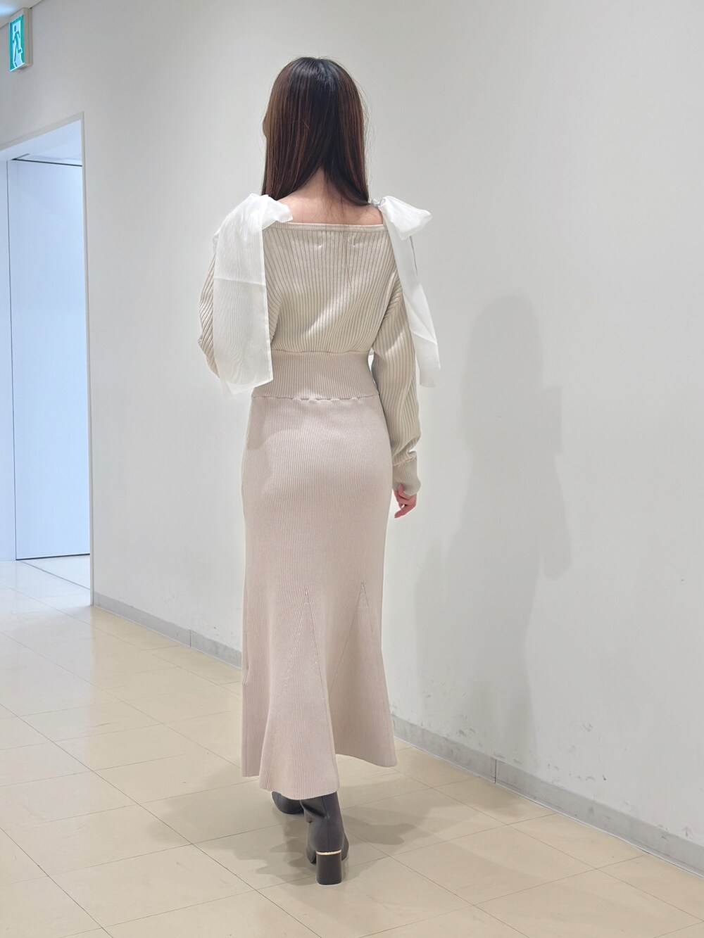 ホワイト系のワンピース、ブラウン系のブーツを着用したレディースの冬コーディネートの4枚目の写真