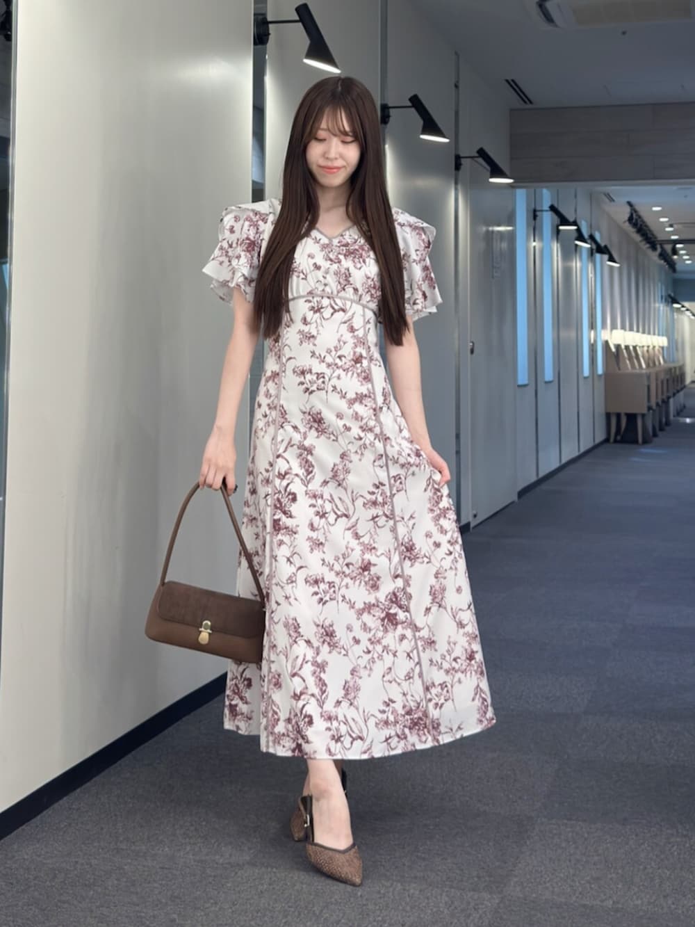 ブラウン系のハンドバッグ、ブラウン系のパンプス、レッド系のワンピースを着用したレディースの夏コーディネートの2枚目の写真